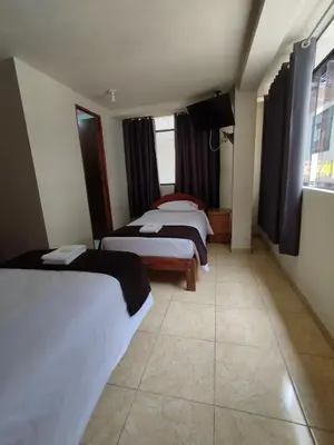 a hotel room with two beds and a window at Kuntur House Machupicchu in Machu Picchu