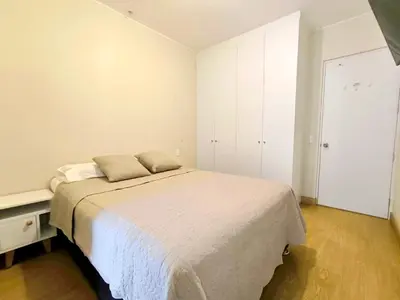 a white bedroom with a bed and a closet at Departamento en Santa Catalina cerca a San Isidro in Lima