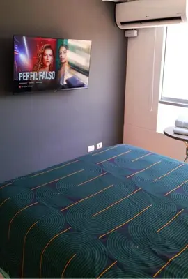 a room with a carpet with a tv on the wall at El Derby 511 Aparts de 3 Dorm con Aire Acondicionado in Lima