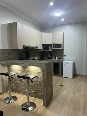 a kitchen with a counter and two bar stools at Huacachina Lagoon House in Ica