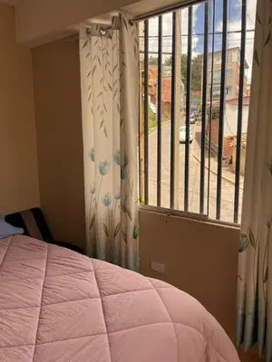 a bedroom with a bed and a window with a view at Mirador Vip Apartment in Cusco