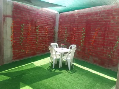 a table and chairs in a room with a red brick wall at Casa, Playa el pasamayito sur de asia in Asia