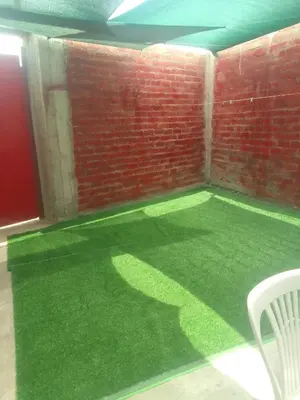 a room with a green floor and a brick wall at Casa, Playa el pasamayito sur de asia in Asia