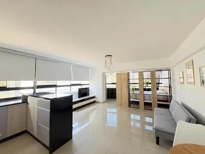 a kitchen and living room with a couch and a television at Apartment in Lima in Lima
