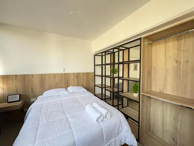 a bedroom with a bed with white sheets and towels at Apartment in Lima in Lima
