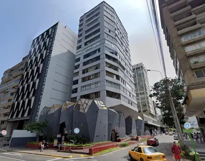 a yellow taxi parked in front of a tall building at Apartment in Lima in Lima
