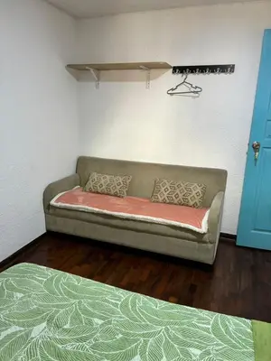 a couch sitting in a room with a wall at Green Love in Lima