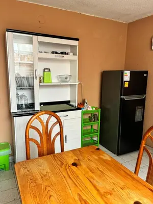 a kitchen with a wooden table and a black refrigerator at Green Love in Lima