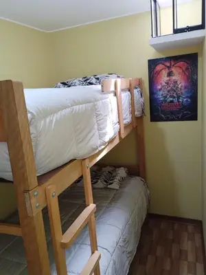 two bunk beds in a small room with a bedskirts at Habich Apartment in Lima