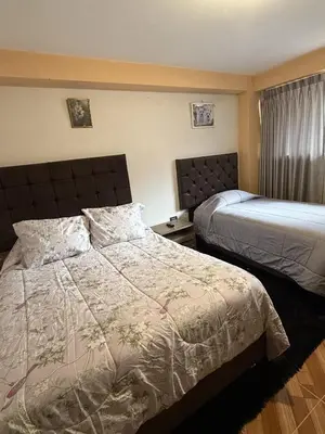 a hotel room with two beds and a window at Chabela Host in Cusco