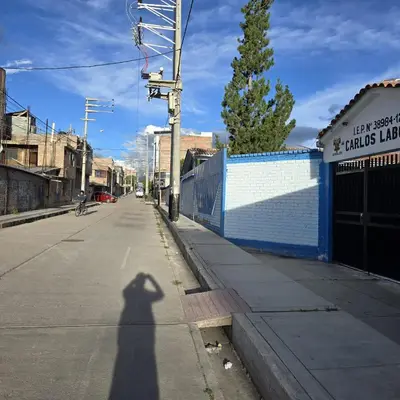 a shadow of a person riding a bike down a street at Departamento completo acogedor y con estacionamiento in Ayacucho