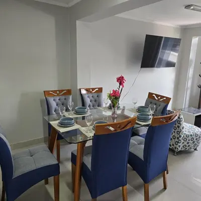 a dining room with a table with blue chairs at Departamento completo acogedor y con estacionamiento in Ayacucho