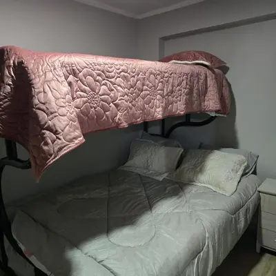 a bed with a pink blanket on top of it at Departamento completo acogedor y con estacionamiento in Ayacucho