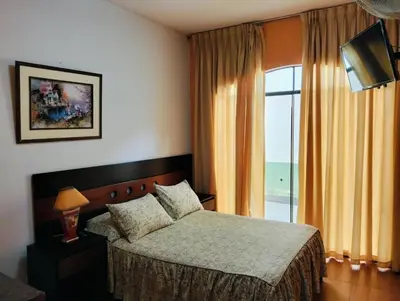 a bedroom with a bed and a large window at Tambo II Hotel Campestre in Cieneguilla