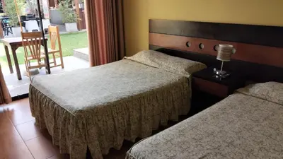 two beds in a hotel room with a window at Tambo II Hotel Campestre in Cieneguilla
