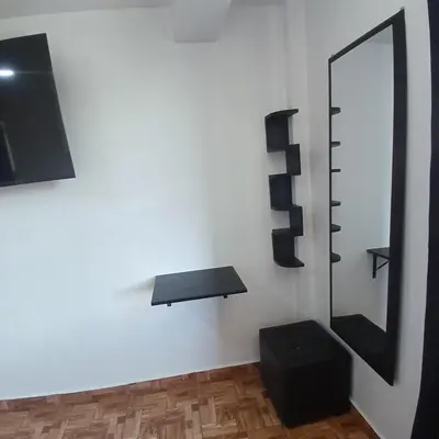 a bathroom with a mirror and a black stool at HOSTAl EGIPTO in Ayacucho