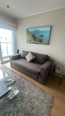a living room with a brown couch and a table at Urbano Apartments Miraflores Pardo in Lima