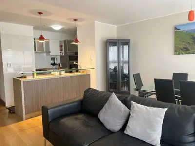 a living room with a couch and a kitchen at Urbano Apartments Miraflores Pardo in Lima