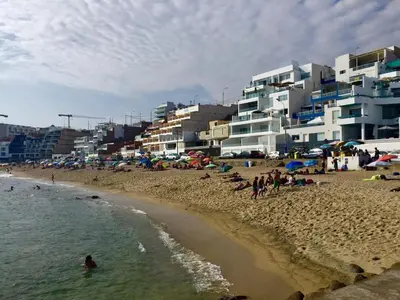 a beach with a bunch of people in the water and buildings at Departamento San Bartolo, Excellent Location! in San Bartolo