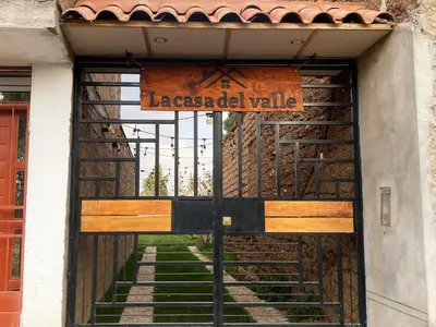 a door to a gate with a sign on it at La Casa del Valle - Huaripampa in Huaripampa
