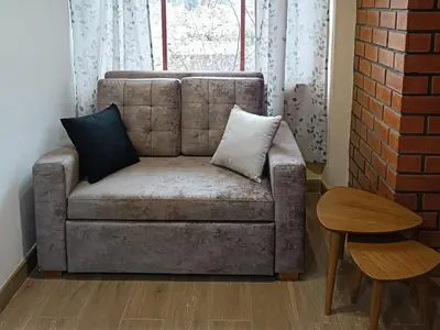 a couch with two pillows on it in a living room at La Casa del Valle - Huaripampa in Huaripampa