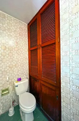 a bathroom with a toilet and a wooden door at Casa Molinera in Lima