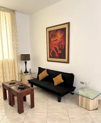 a living room with a black couch and a table at Casa Molinera in Lima