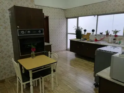 a kitchen with a table and a small table and a kitchen with a counter at Casa Molinera in Lima