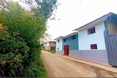 a dirt road next to a white building with a red door at RiKCHARiY in Primavera