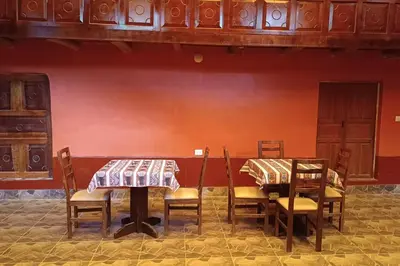a dining room with two tables and chairs and a red wall at RiKCHARiY in Primavera