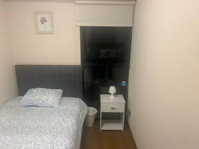 a small bedroom with a bed and a night stand at Luxury Aparment in San Isidro in Lima