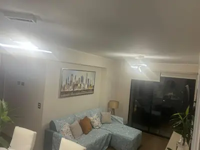 a living room with a blue couch and a tv at Luxury Aparment in San Isidro in Lima