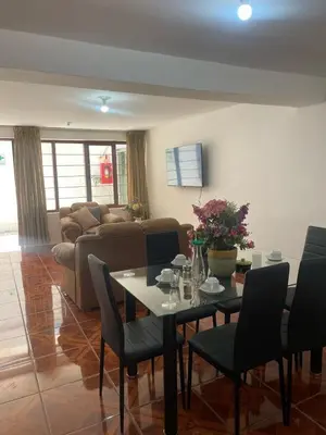 a living room with a table and chairs and a couch at Quechuas in Cusco