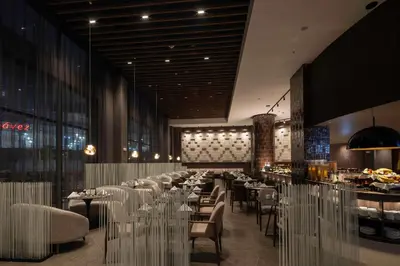 a restaurant with tables and chairs and a bar at Wyndham Grand Costa Del Sol Lima Airport in Lima