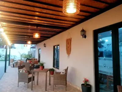 a patio with a wooden ceiling and a table and chairs at Hotel Sol de Ocucaje #4 in Ica