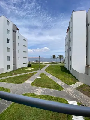 a view of two white buildings with a grass courtyard at Dpto en Paracas con vista al Mar in Paracas