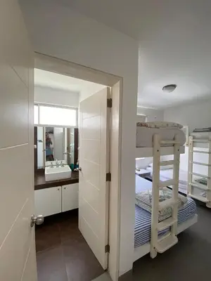 a bedroom with bunk beds and a bathroom with a mirror at Dpto en Paracas con vista al Mar in Paracas