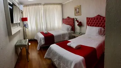 a hotel room with two beds with red headboards at INTI KILLA Hostel in Lima