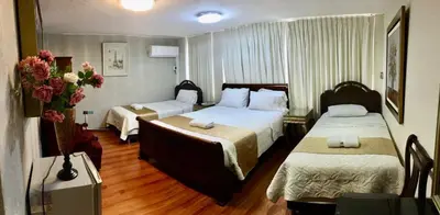 a hotel room with two beds and flowers in it at INTI KILLA Hostel in Lima
