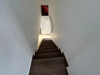 a staircase in a white building with a red painting at Dormitorio con baño en departamento Miraflores in Lima