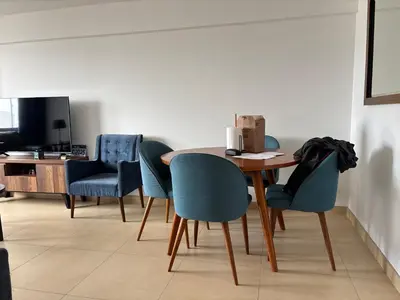 a dining room with a table and blue chairs at Dormitorio con baño en departamento Miraflores in Lima
