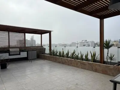 an outdoor patio with a view of the water at Dormitorio con baño en departamento Miraflores in Lima