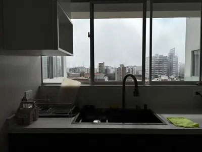 a kitchen with a view of a city from a window at Dormitorio con baño en departamento Miraflores in Lima