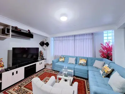 a living room with a blue couch and a tv at Jerusalen Inn-Dep 4 in Cusco