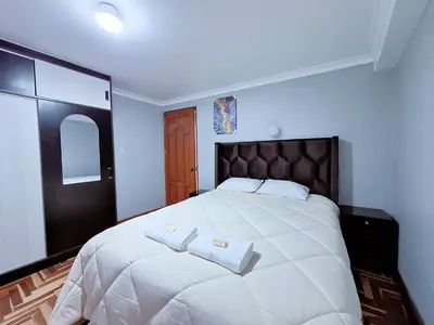 a bedroom with a large white bed with two towels on it at Jerusalen Inn-Dep 4 in Cusco