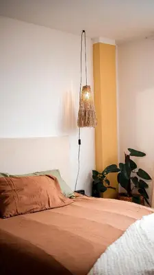 a bedroom with a bed with a lamp and a plant at House Sacha 1BR Great View Huanuco in Huánuco