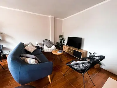 a living room with a blue couch and a television at House Sacha 1BR Great View Huanuco in Huánuco