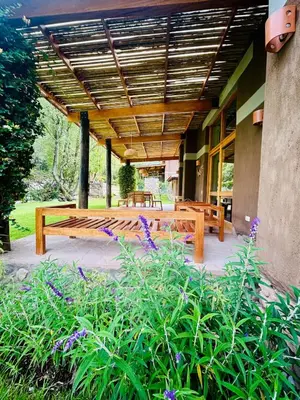 a patio with a wooden table and benches at Luxury house in Urubamba, Cusco, Perú in Urubamba