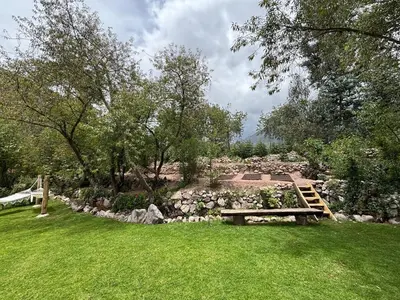 a park with a bench and a rock garden at Luxury house in Urubamba, Cusco, Perú in Urubamba