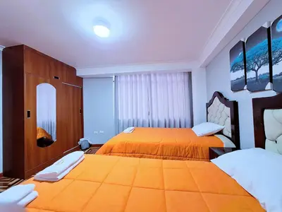 two beds in a room with orange bedding at Jerusalen Inn-Dep 2 in Cusco